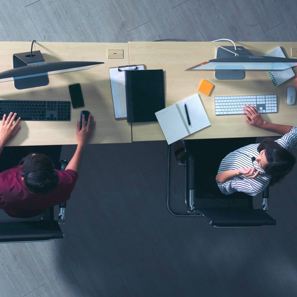 Top view young customer services care operators working night shift in call center for helping assistance client in workplace at night time