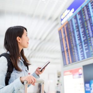 woman-looking-at-information-board-and-holding-cel-3HS6WTM