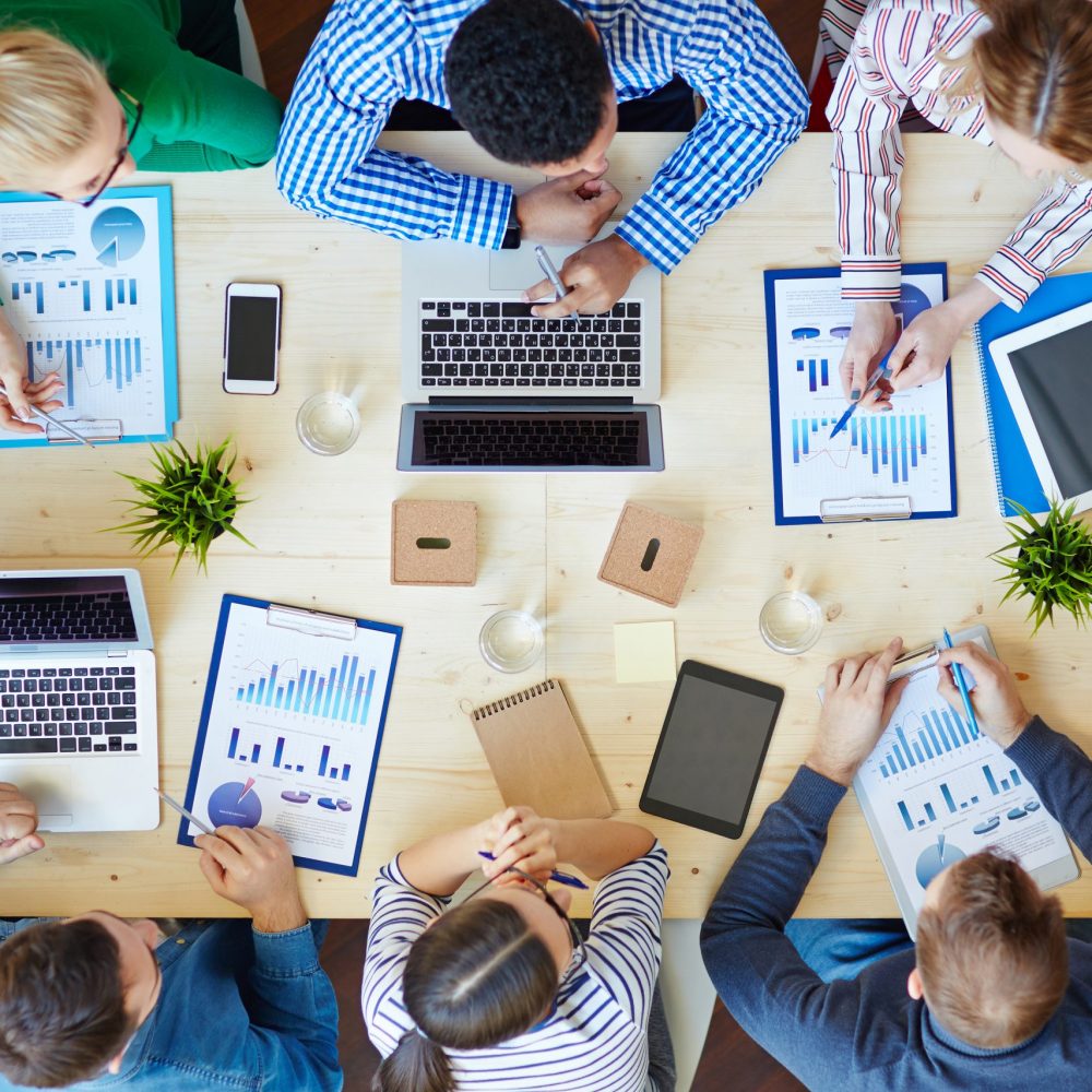 Above view of business team sitting around table and working